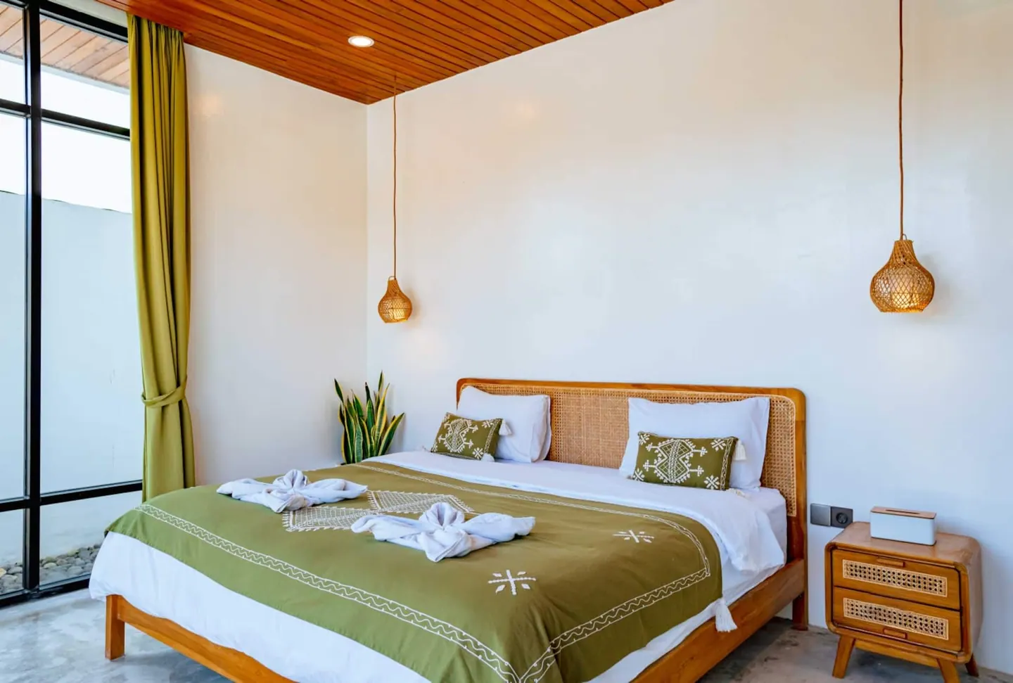 Bedroom 1 with a King Koil super-king bed, rattan headboard and en-suite rain shower